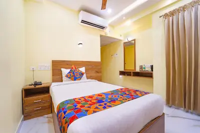 a bedroom with a bed with a colorful blanket on it at FabHotel INK - Nr Coimbatore North Railway Station in Coimbatore