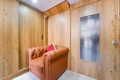 a leather chair in a room with wooden walls at FabHotel INK - Nr Coimbatore North Railway Station in Coimbatore