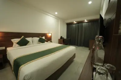 a bedroom with a large bed in a room at Georjoys Hotels & Resorts in Kalpetta