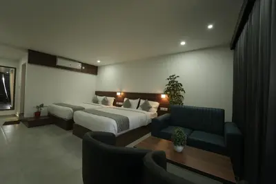 a hotel room with two beds and a couch at Georjoys Hotels & Resorts in Kalpetta