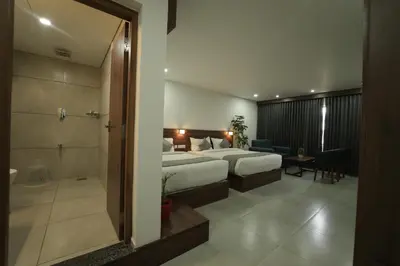 a hotel room with a bed and a bathroom at Georjoys Hotels & Resorts in Kalpetta