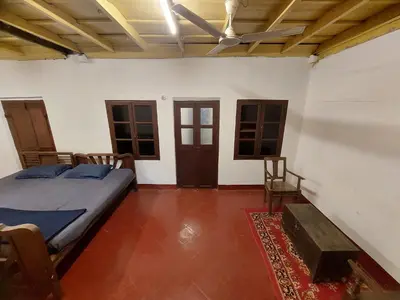 a bedroom with a bed and two chairs in it at VIHA The Heaven in Meppādi