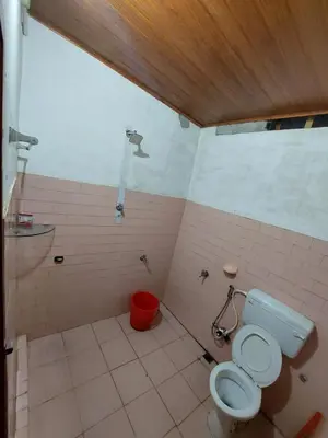a bathroom with a toilet and a red bucket at VIHA The Heaven in Meppādi