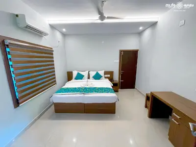 a bedroom with a bed and a window in it at Milife Medicity Perashannoor in Kuttippuram