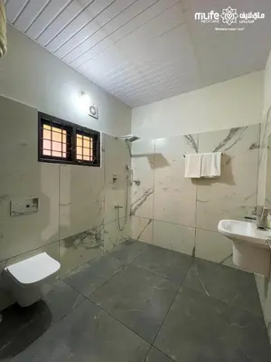 a bathroom with a shower and a toilet and a sink at Milife Medicity Perashannoor in Kuttippuram