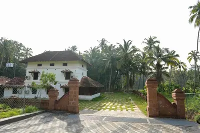 a house with a fence in front of it at Krishnapuram Heritage Resort in Karimpuzha