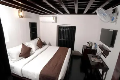 a bedroom with a bed and a television in it at Krishnapuram Heritage Resort in Karimpuzha