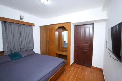 a bedroom with a bed and a flat screen tv at Travel & Stay in Ooty