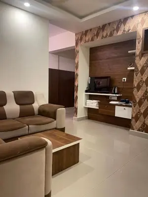 a living room with a couch and a tv at VVP Rooms in Cochin