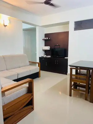 a living room with a couch and a table at VVP Rooms in Cochin