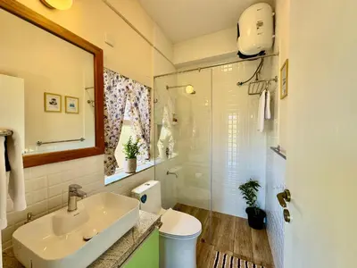 a bathroom with a sink and a toilet and a mirror at Jade Pearl Kotagiri in Kotagiri