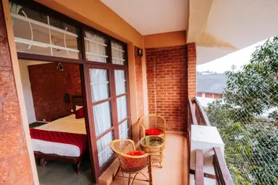 a room with a balcony with a bed and a bedroom at Nirmallyam Residency Hotel in Edappāl