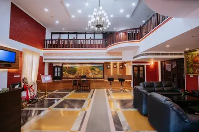 a large lobby with couches and a television in a building at Nirmallyam Residency Hotel in Edappāl