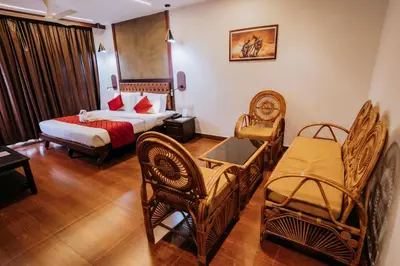 a hotel room with a bed and chairs and a couch at Nirmallyam Residency Hotel in Edappāl
