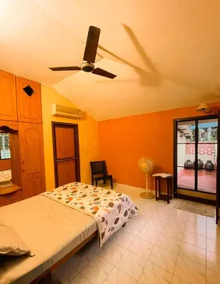 a bedroom with a bed and a ceiling fan at Bough'n Villa 1B - Balcony room in Kozhikode
