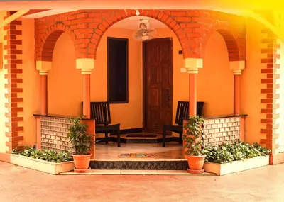 an entrance to a building with two benches and plants at Bough'n Villa 1B - Balcony room in Kozhikode