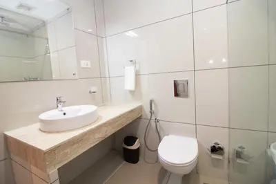 a white bathroom with a sink and a toilet at Cloud Five in Munnar