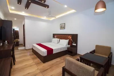 a bedroom with a bed and a desk and a chair at Cloud Five in Munnar
