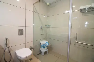 a bathroom with a shower and a toilet and a glass shower stall at Cloud Five in Munnar