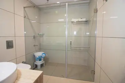 a bathroom with a glass shower with a toilet at Cloud Five in Munnar
