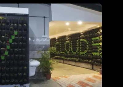a bathroom with a toilet and a wall of wine bottles at Cloud Five in Munnar