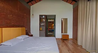 a bedroom with a large white bed in a room at Solace Villa 2BHK AC in Kakkayam
