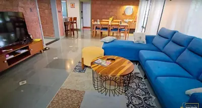 a living room with a blue couch and a table at Solace Villa 2BHK AC in Kakkayam