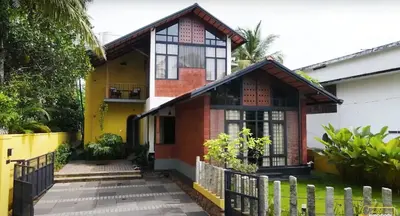 a house with a fence in front of it at Solace Villa 2BHK AC in Kakkayam