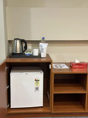 a small kitchen with a refrigerator and a table at Bloomax Residency in Malappuram
