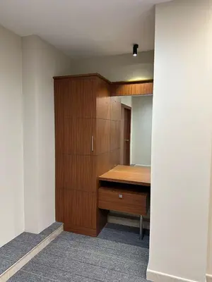 a room with a wooden desk and a mirror at Bloomax Residency in Malappuram