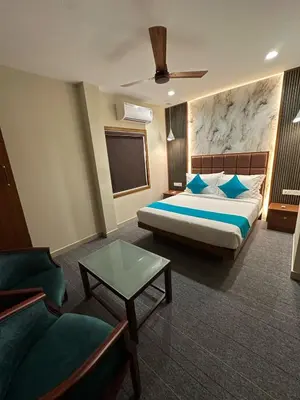 a hotel room with a bed and a couch at Bloomax Residency in Malappuram