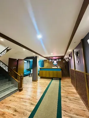 a lobby with stairs and a bar in the background at Bloomax Residency in Malappuram