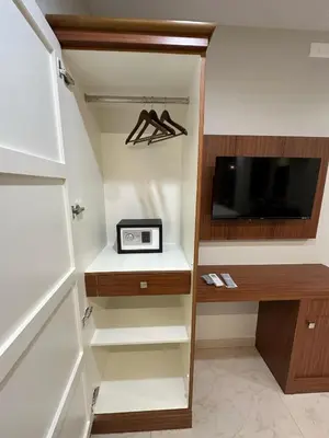 a walk in closet with a tv and a desk at Bloomax Residency in Malappuram