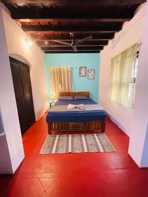 a bedroom with a bed in the middle of a room at Casa Shanti in Kannur