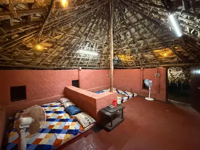an attic room with a room with a bed in it at Jungle Farm House in Kollengode