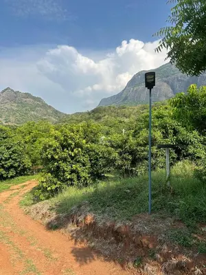 a street sign in the middle of a dirt road at Jungle Farm House in Kollengode