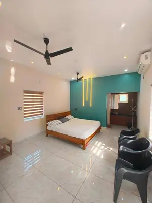 a bedroom with a bed and a ceiling fan at Jungle Farm House in Kollengode