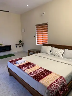 a bedroom with a large bed in a room at Jungle Farm House in Kollengode