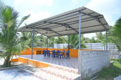 a patio with blue tables and chairs under a canopy at Bhuvi farm & homestay in Channapatna