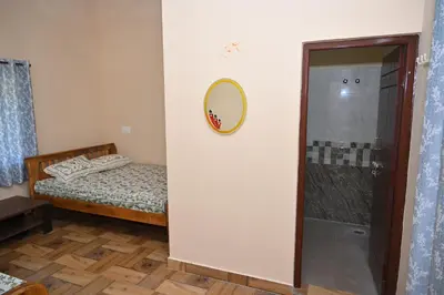 a bedroom with a bed and a mirror and a shower at Bhuvi farm & homestay in Channapatna