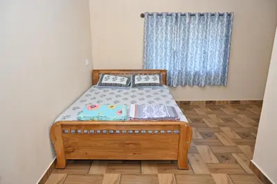 a small bed in a room with a window at Bhuvi farm & homestay in Channapatna