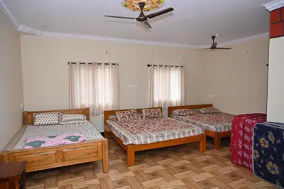a room with three beds and a ceiling at Bhuvi farm & homestay in Channapatna