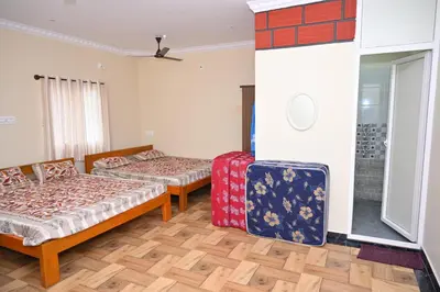 a room with two beds and luggage in it at Bhuvi farm & homestay in Channapatna