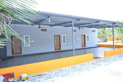 a yellow bench in front of a building at Bhuvi farm & homestay in Channapatna