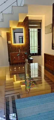 a living room with a glass table with a vase on it at joys villa self service villa in Cherai Beach