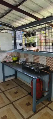 a counter in a kitchen with a table with dishes at joys villa self service villa in Cherai Beach