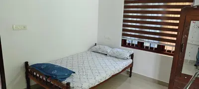 a small bed in a room with a window at joys villa self service villa in Cherai Beach