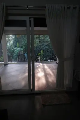 an open glass door with a view of a patio at Nutmeg Haven Plantation stay in Chewarra