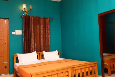 a bedroom with a wooden bed with blue walls at Hillside Green Valley Comfort Stay in Gūdalūr
