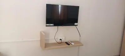 a flat screen tv hanging on a white wall at Sri Annapoorna Luxury Apartment - Serviced Apartment in Coimbatore